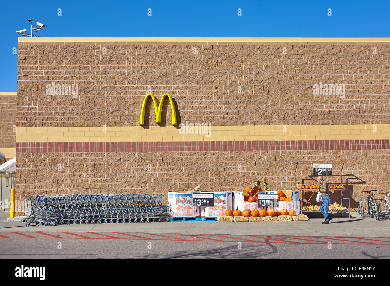 Denver, Stati Uniti d'America - 16 Ottobre 2016: l'uomo non identificato lasciando Walmart store, visibile McDonald's logo e zucche decorative Halloween vendita. Foto Stock