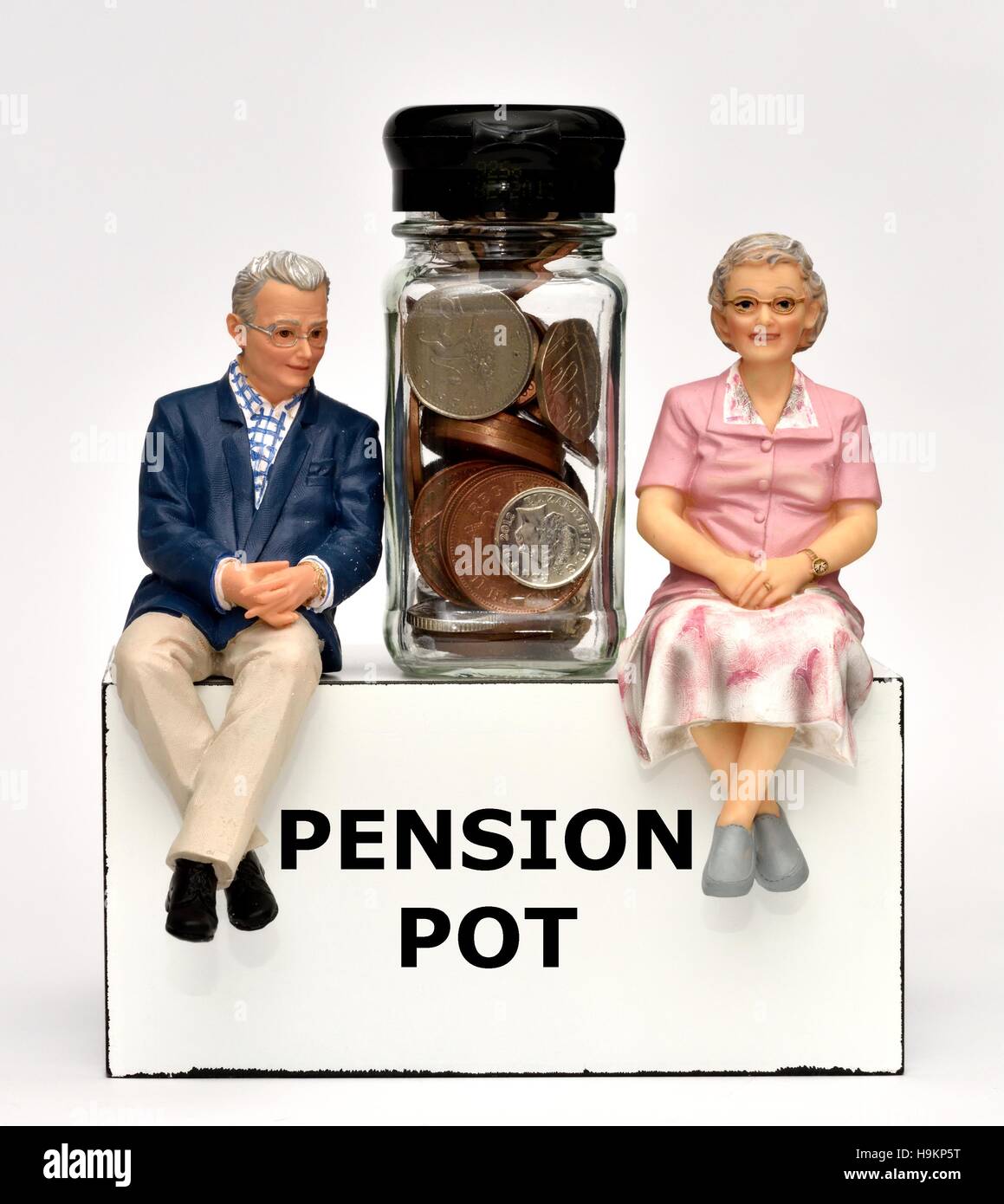 Due figurine di pensionati con una pensione pot vaso di denaro. Foto Stock