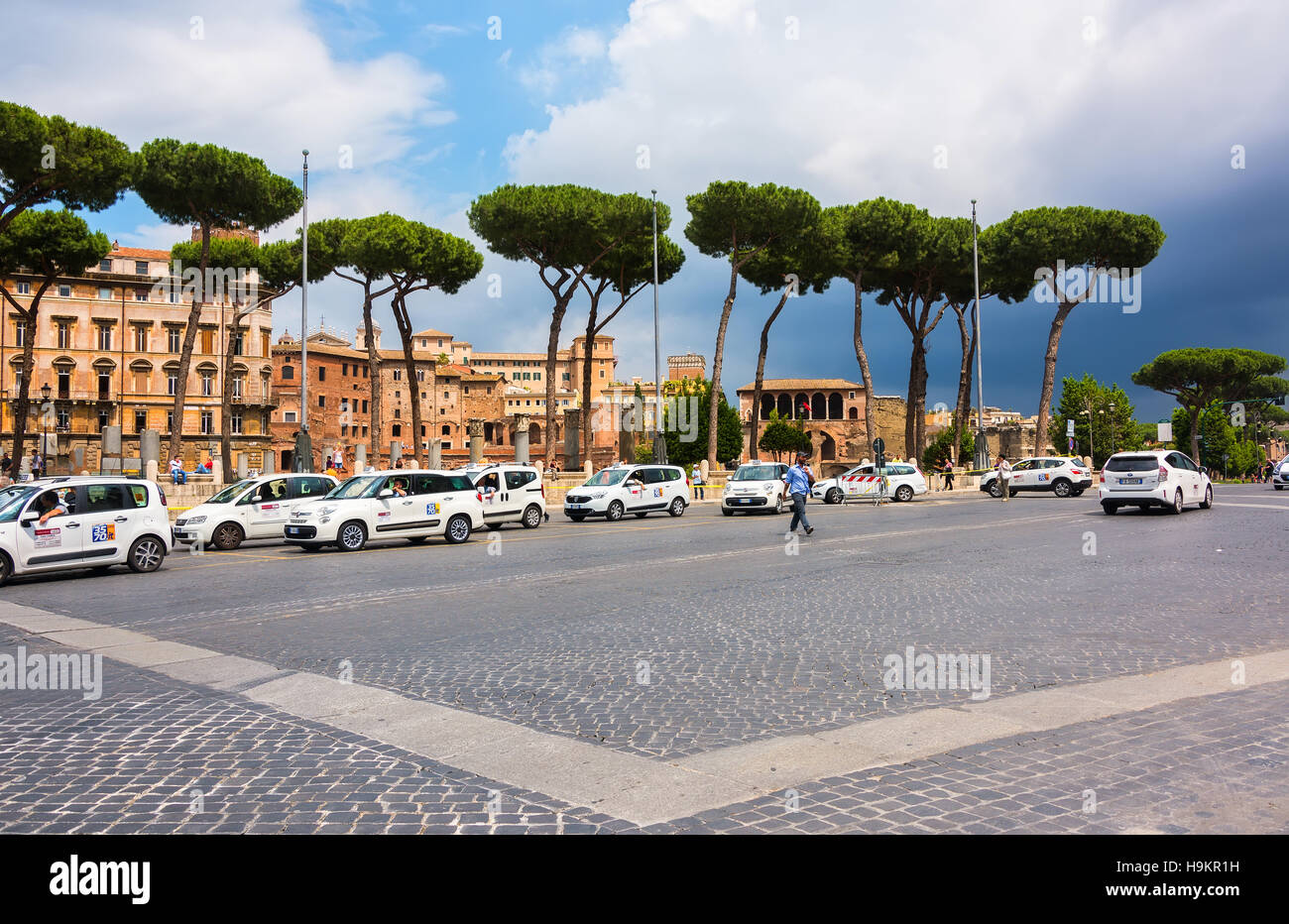 I Taxi schierate in attesa per i clienti lungo una strada principale molto trafficata in Roma, Italia. Foto Stock