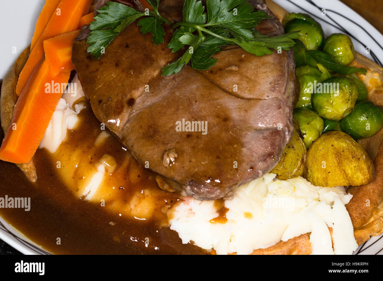 Un pasto a base di carne di cervo scozzese Scamone bistecca con patate, verdure e salsa in un gigante di Yorkshire pudding. Foto Stock