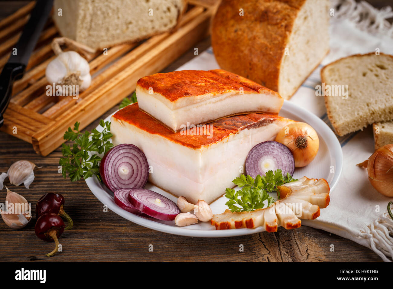 Pancetta di grasso su una piastra bianca con prezzemolo e cipolla Foto Stock
