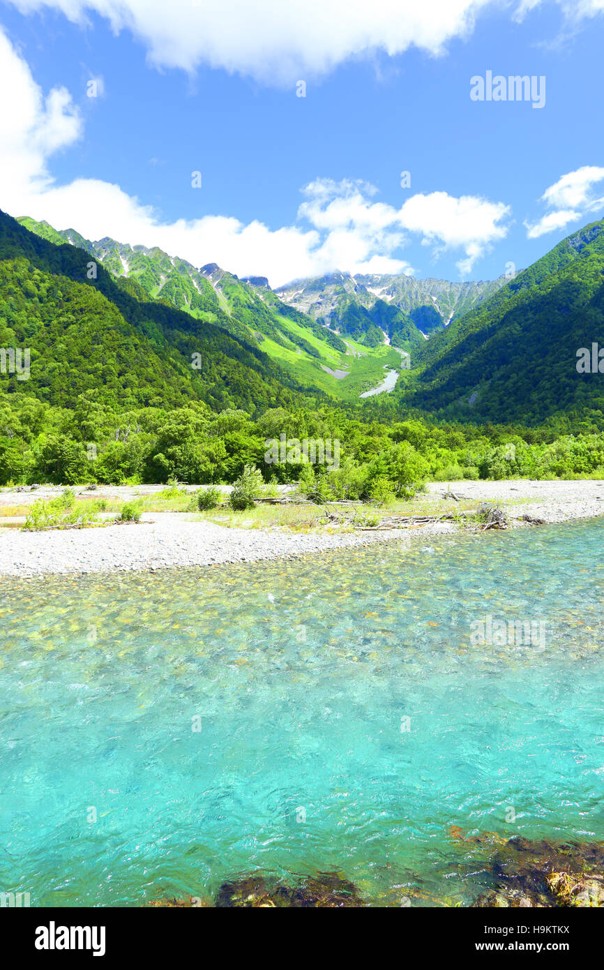 Incontaminato, crystal clear Azusa fiume che scorre al di sotto di Snow capped Hotaka Dake in montagna idilliaco delle Alpi Giapponesi villaggio di Kamikochi Foto Stock