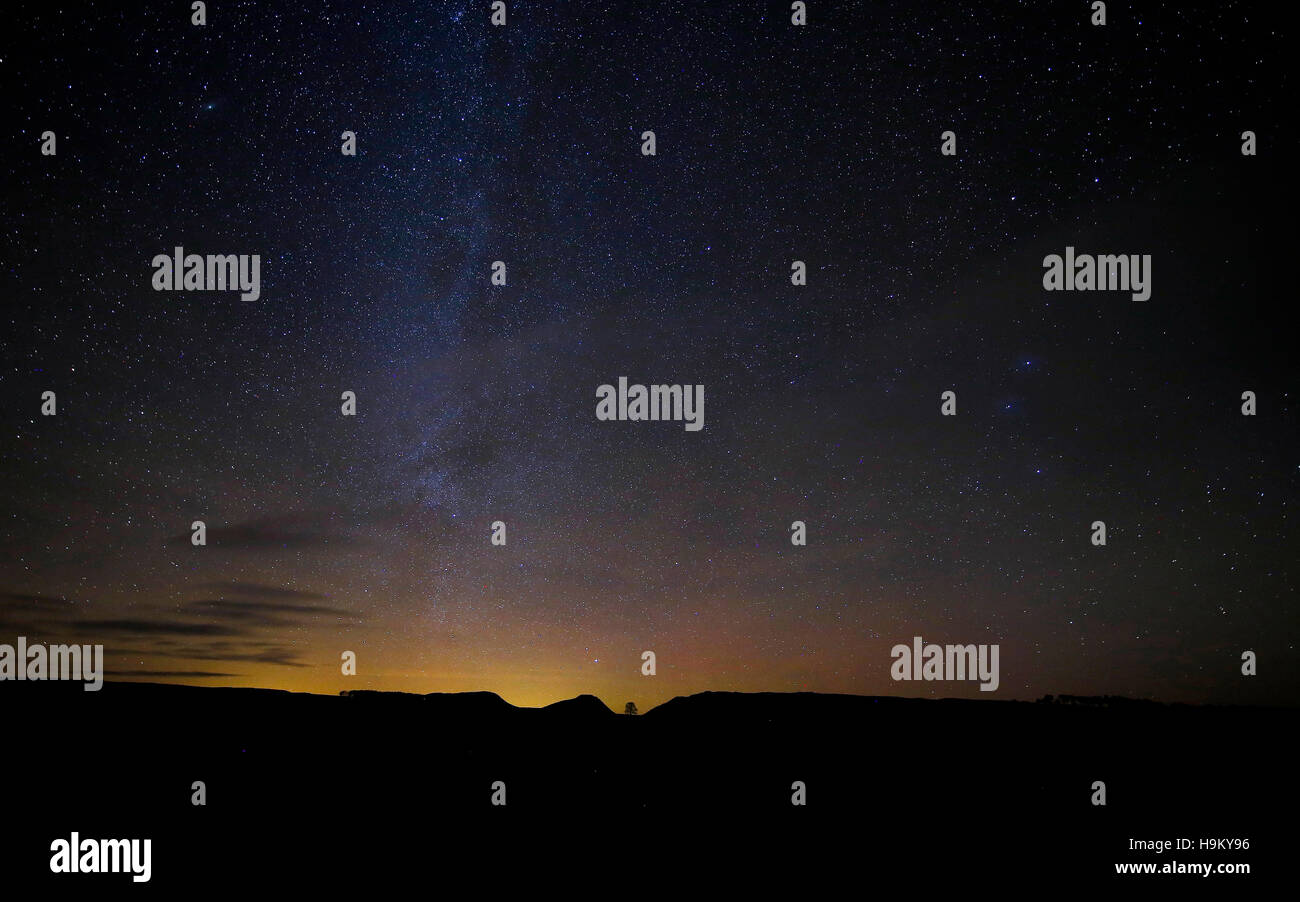 Stelle e luci del nord sono visibili al di sopra del gap di Platano albero sul vallo di Adriano nel Parco nazionale di Northumberland, reso famoso dal film Robin Hood Principe dei ladri interpretato da Kevin Costner. Foto Stock