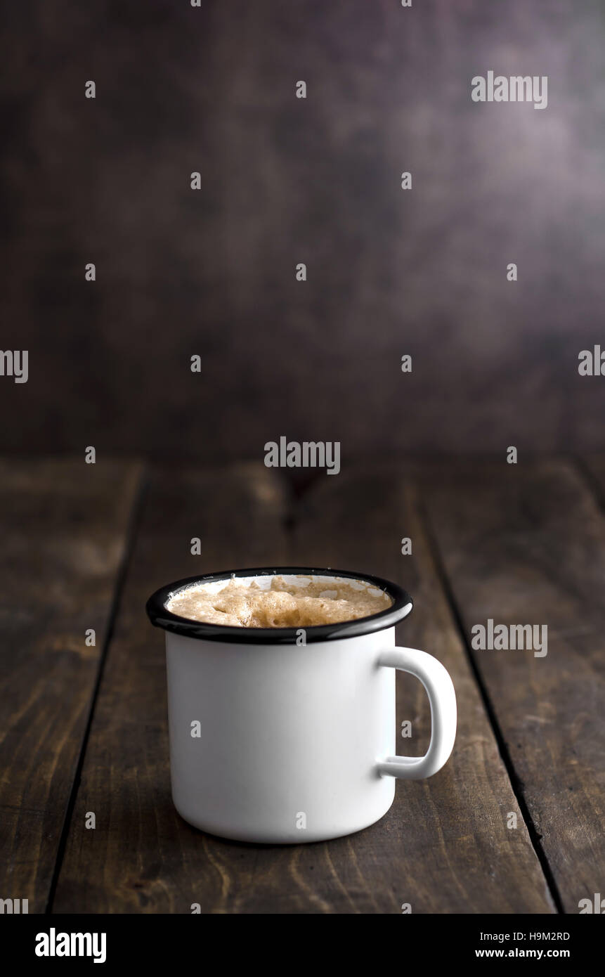 Il caffè nel vintage tazza di stagno sul vecchio sfondo di legno Foto Stock