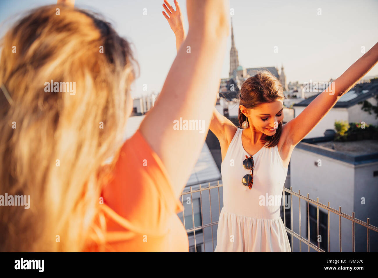 Austria, Vienna, due donne che danzano sulla terrazza sul tetto Foto Stock