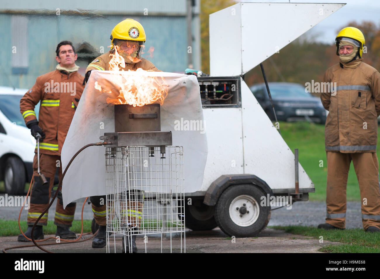 La salute e la sicurezza sul sito di formazione antincendio utilizzando una coperta antincendio per estinguere una padella di olio sotto la guida REGNO UNITO Foto Stock