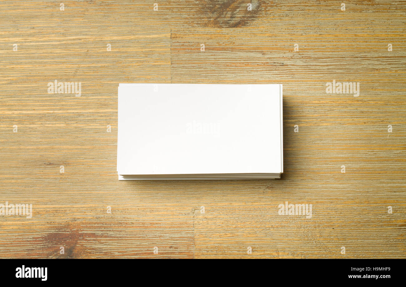 Pila di bianco allineate le schede aziendali su un marrone tavolo in legno Foto Stock