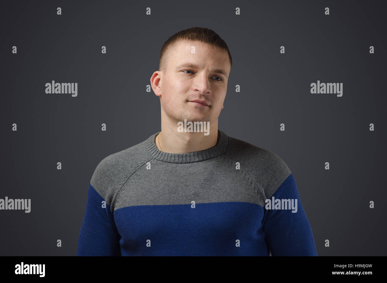 Ritratto di un giovane uomo gay che sorride. Foto emotivo in studio su sfondo nero Foto Stock