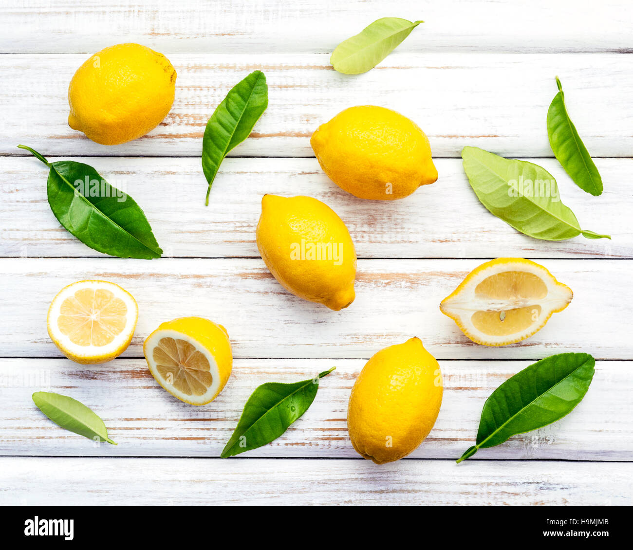 Limoni freschi Limoni e foglie sul legno rustico sfondo. Fre Foto Stock