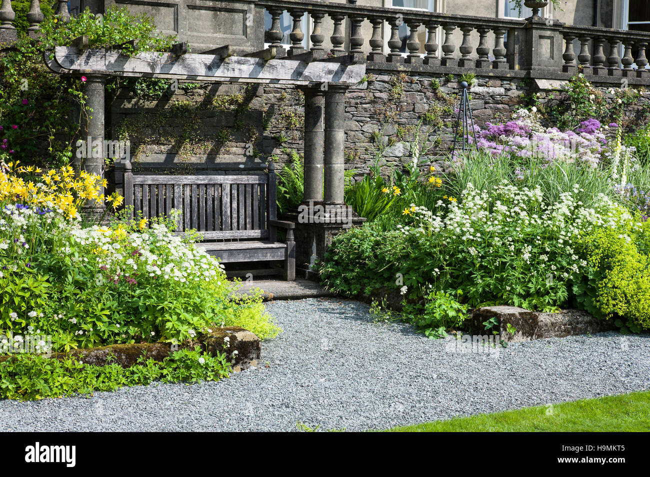 Una sede arbor fiancheggiata da piante erbacee da aiuole a Rydal Hall Cumbria Regno Unito Foto Stock