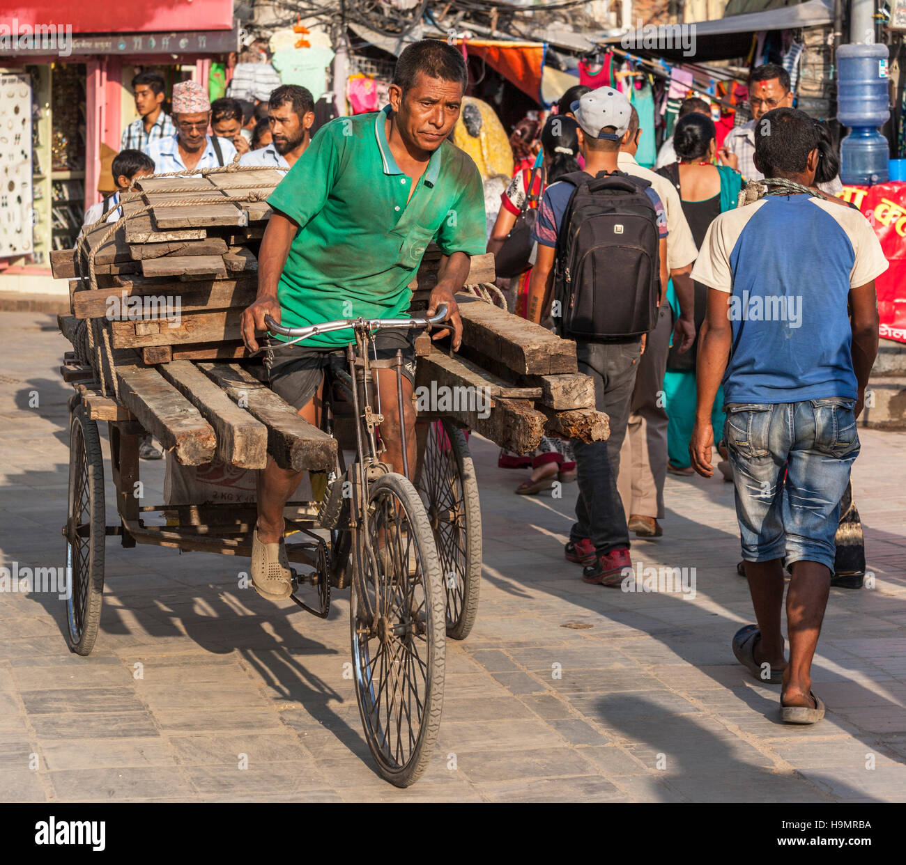 Uomo di legno portante sulla sua bicicletta rimorchio in Kathmandu Foto Stock