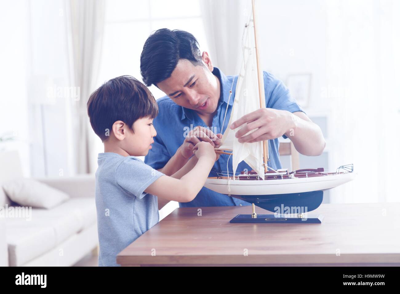 Padre e figlio nella riparazione del modello di vela Foto Stock