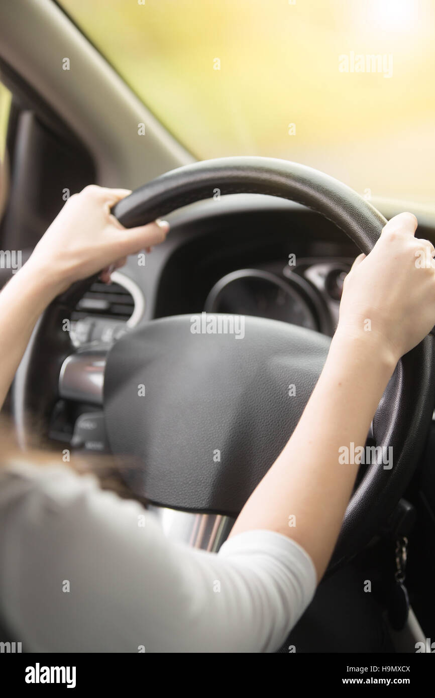 Close-up della femmina di tenere le mani sul volante Foto Stock