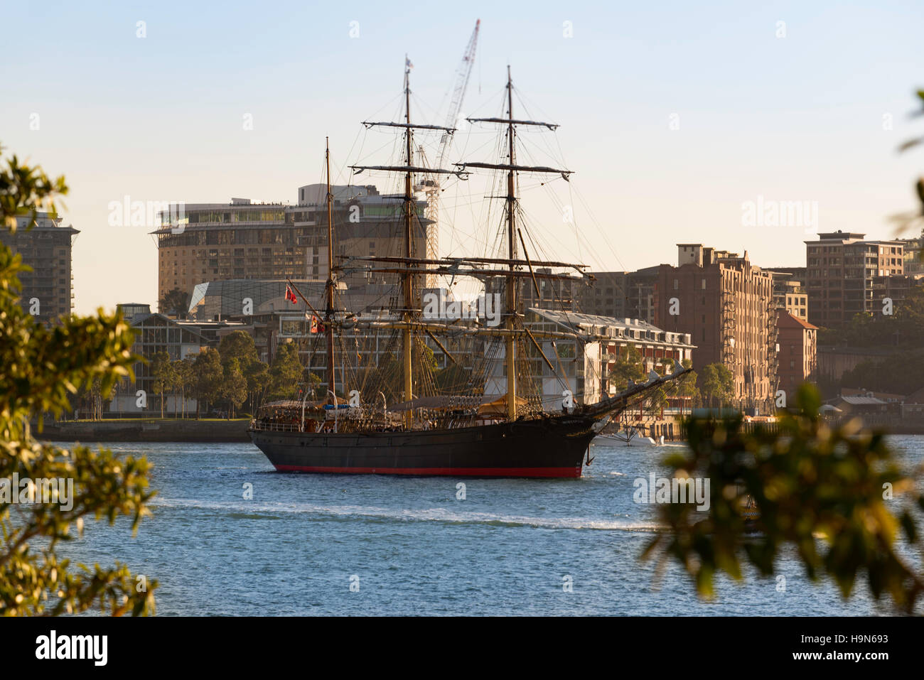 Sydneys Tall Ship, il James Craig scivola passato Barangaroo promontorio nel porto di Sydney per alcuni twilight vela Foto Stock