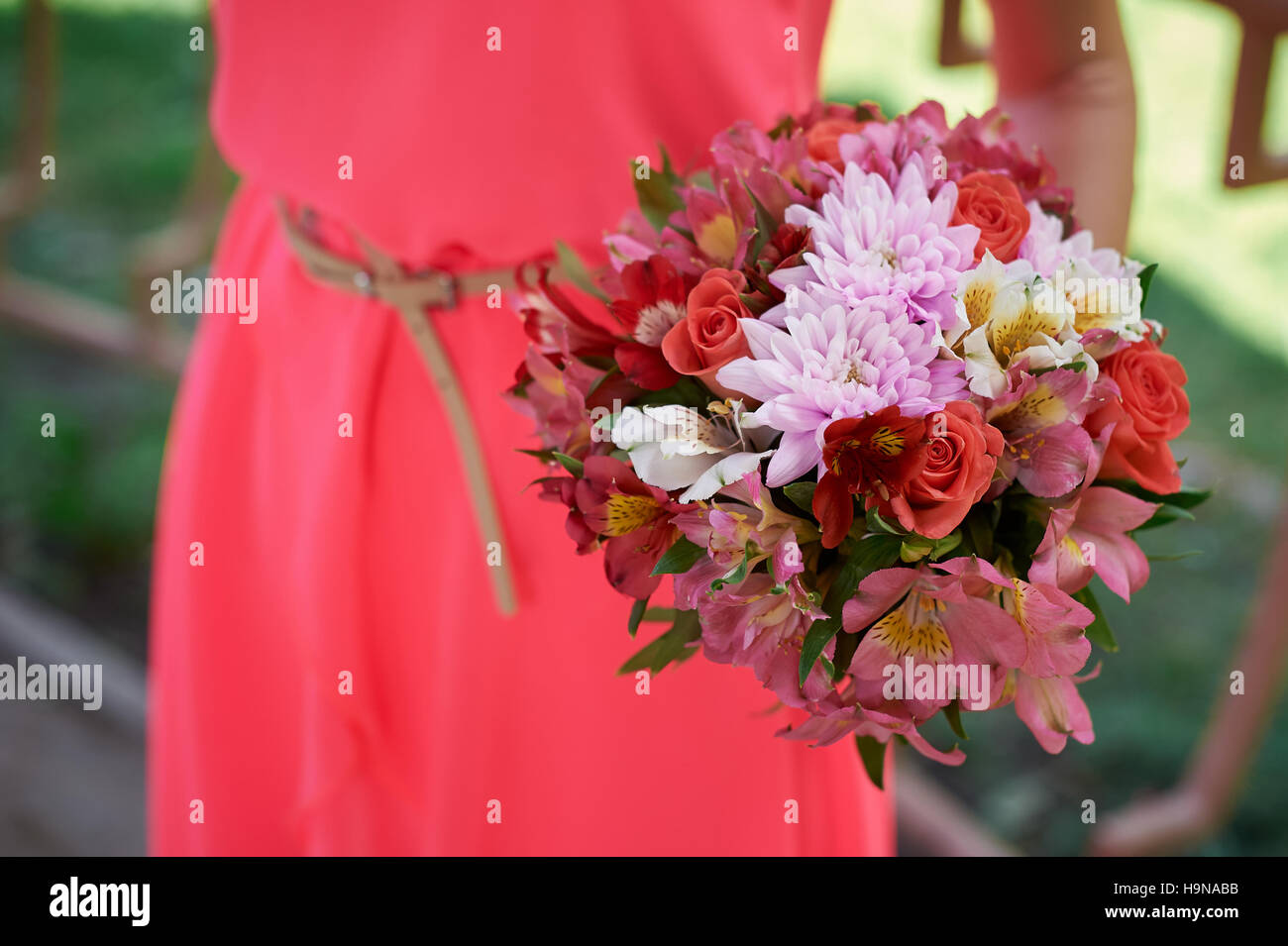 Bridesmaids in un abito rosso con bouquet di nozze Foto Stock