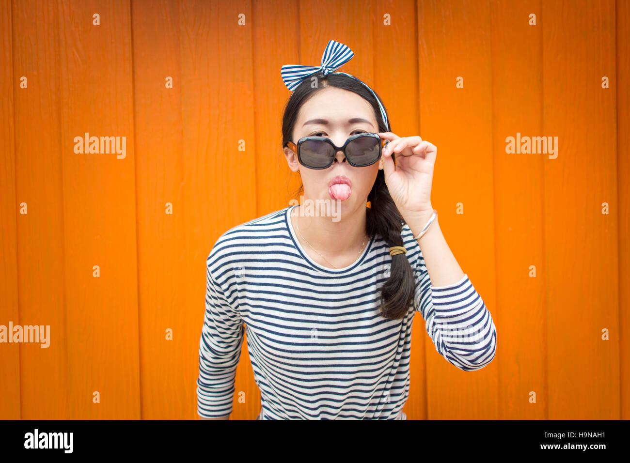 Moda ragazza in posa contro colorato sfondo di legno Foto Stock