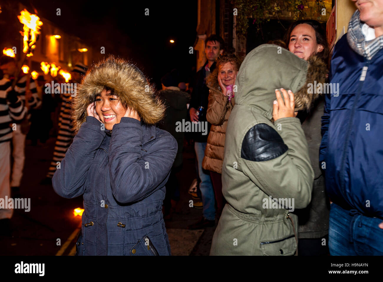 Bambini coprire le loro orecchie durante una processione rumorosa durante l annuale di Guy Fawkes celebrazioni di notte, Lewes, Sussex, Regno Unito Foto Stock