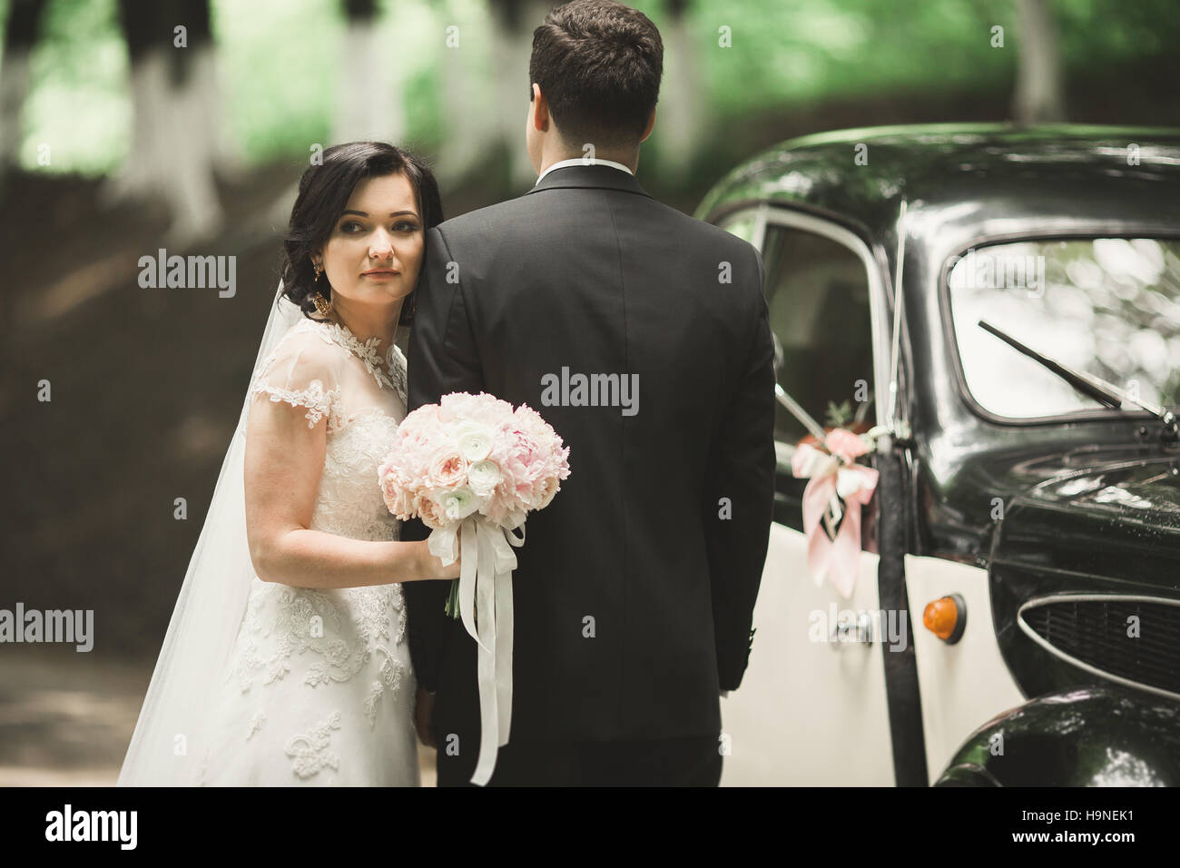 Felice sposa giovane, l uomo e la moglie di baciare vicino in stile retro vettura Foto Stock