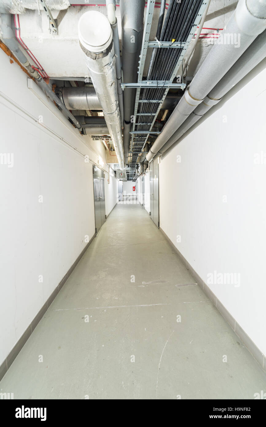 Lungo corridoio tecnico nell'edificio degli uffici Foto Stock