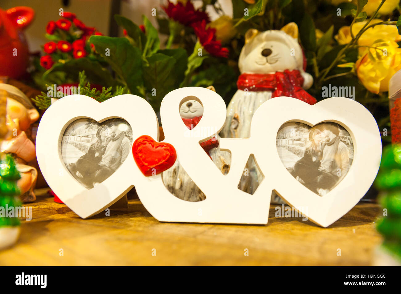 A forma di cuore cornice fotografica sulla tavola di legno contro lo sfondo di giocattoli di Natale Foto Stock