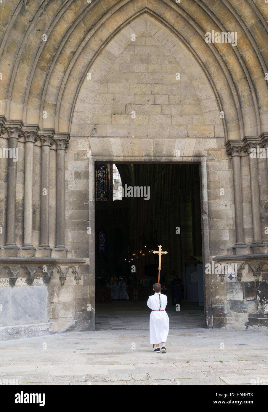 Un chierichetto tenendo una croce al di fuori della cattedrale di St Gervais e St Protais, Soissons, Piccardia, Francia, Europa Foto Stock