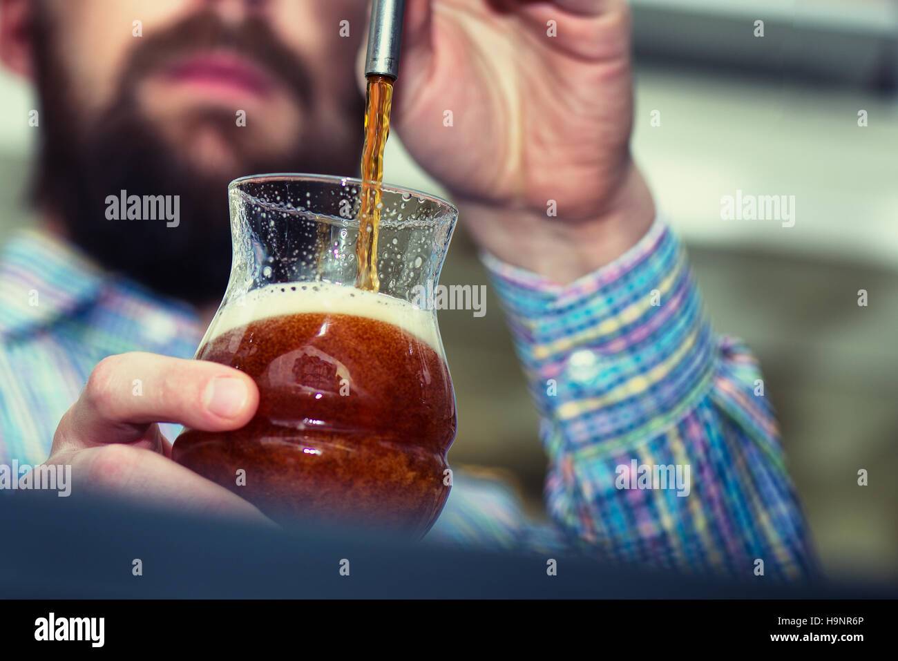 Dark birra versata da barista Foto Stock