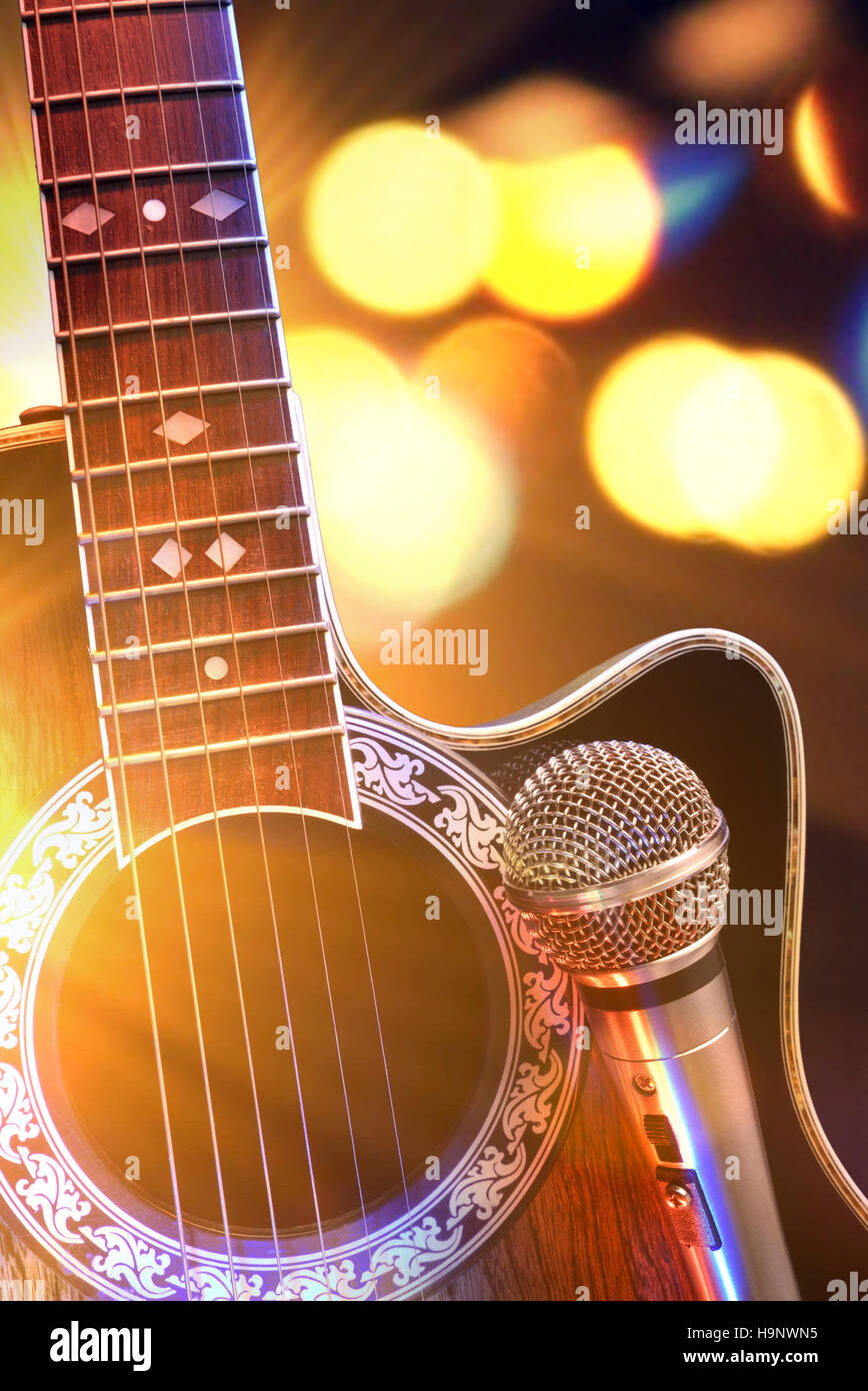La chitarra acustica e un microfono con luci in background. Paese o  concerto di bluegrass concetto. Vista frontale. Composizione orizzontale  Foto stock - Alamy