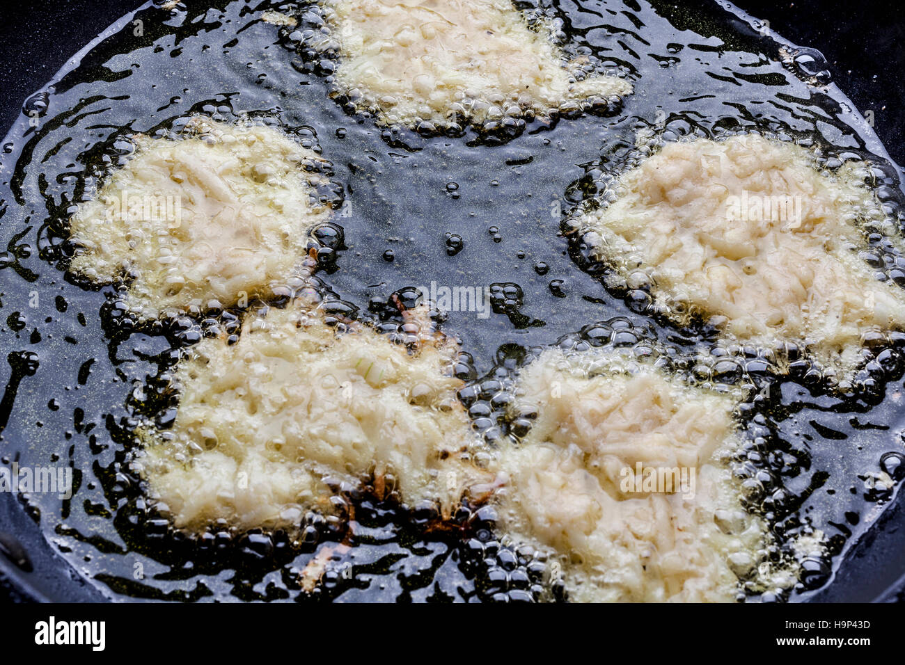 La frittura latkes con lato grezzo fino in olio profondo sulla teglia da sopra Foto Stock