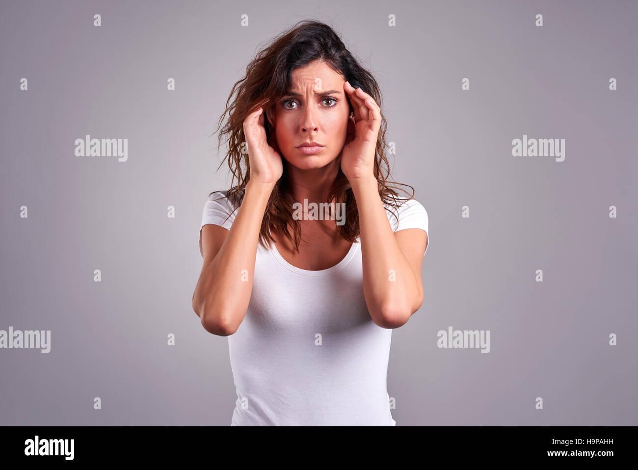 Una giovane e bella donna con un mal di testa e la afferra per la testa Foto Stock