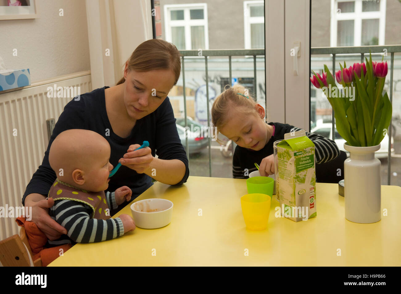 Deutschland, junge Frau mit Kindern in der Küche Foto Stock