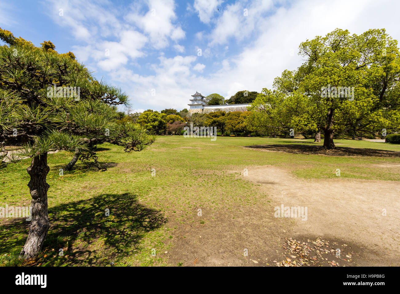 Giappone, Akashi castle, AKA Kishun-jo. a tre piani Hitsujisaru Yagura, torretta, sulla cima di Ishigaki muri in pietra. La primavera con parzialmente blu cielo nuvoloso. Foto Stock