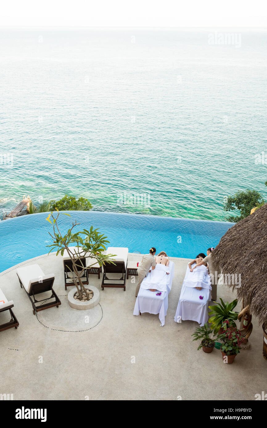 Vista da sopra a due donne di ottenere un massaggio sulla terrazza di un fronte oceano luxury wellness ritiro - Mismaloya, Puerto Vallarta South Shore, Jali Foto Stock