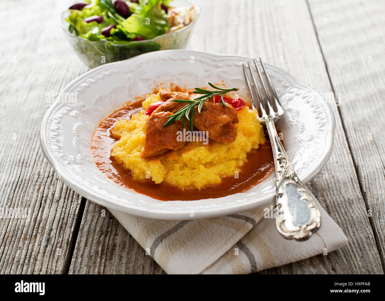 Gulasch con polenta su sfondo di legno vicino fino Foto Stock