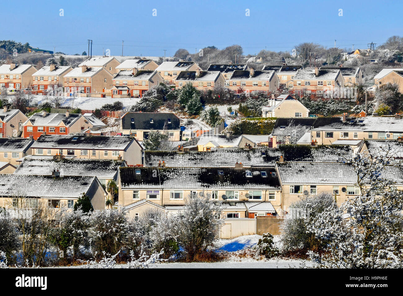 Coperte di neve case suburbane sul pendio di una collina sul lato nord di Cork, Irlanda. Foto Stock