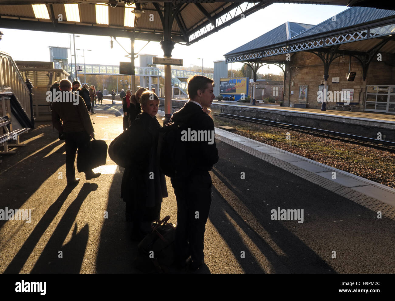 I passeggeri che gettano ombre su una piattaforma ferroviaria, Perth,Scozia,UK Foto Stock