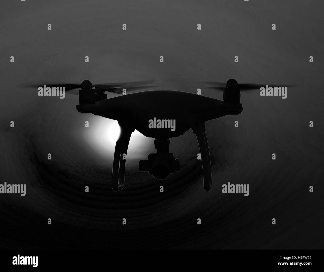 Silhouette Quadrocopters contro lo sfondo del tramonto. Droni volanti nel cielo di sera. Foto Stock