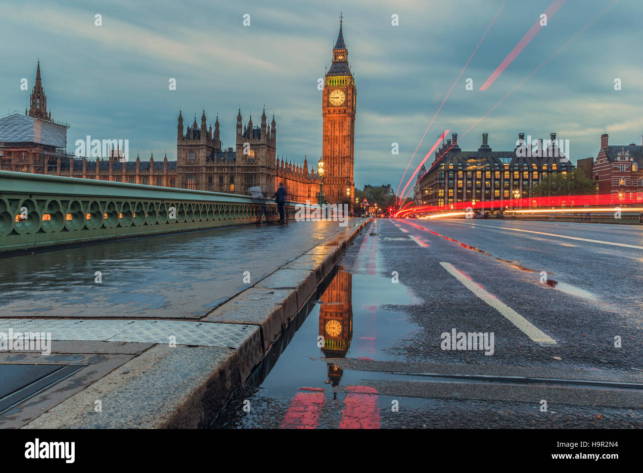 Una riflessione del Big Ben in una pozza sul Westminster Bridge al tramonto. Foto Stock