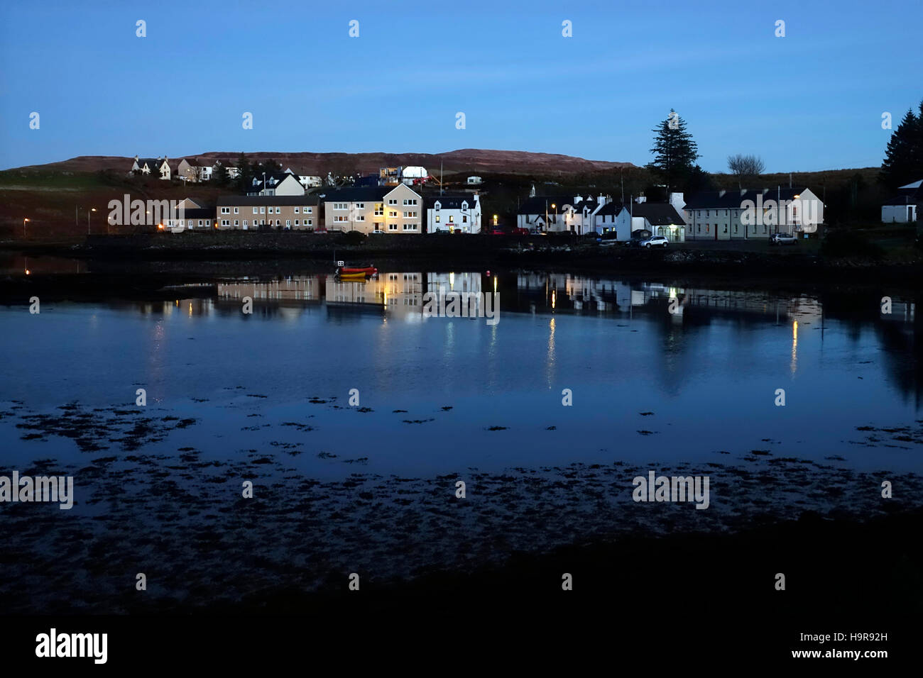 Isle of Mull, Scozia. 24 Novembre, 2016. Le case di Bunessan, Isle of Mull in Scozia si riflette nel mare su questo tranquillo e freddo inverno sera Credito: PictureScotland/Alamy Live News Foto Stock