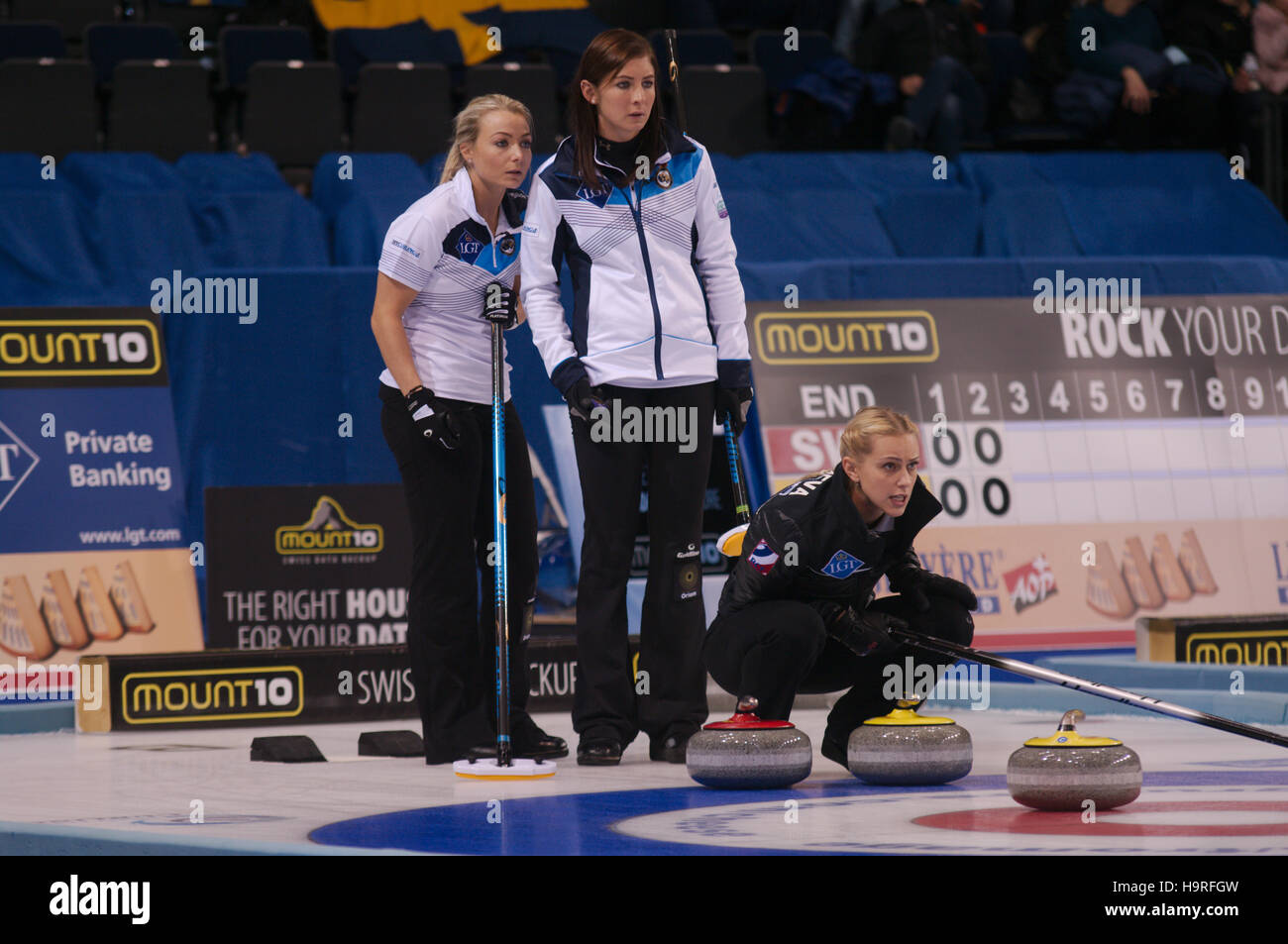 Braehead Arena, Renfrewshire, Scozia, 25 novembre 2016. Il russo saltare Victoris Moiseeva allineando un colpo durante i loro semi finale contro la Scozia nel Le Gruyère AOP Curling europeo Championships 2016. Anna Sloan, sinistra, vice saltare e Eve Muirhead, saltare in Scozia stanno guardando. Credito: Colin Edwards / Alamy Live News Foto Stock