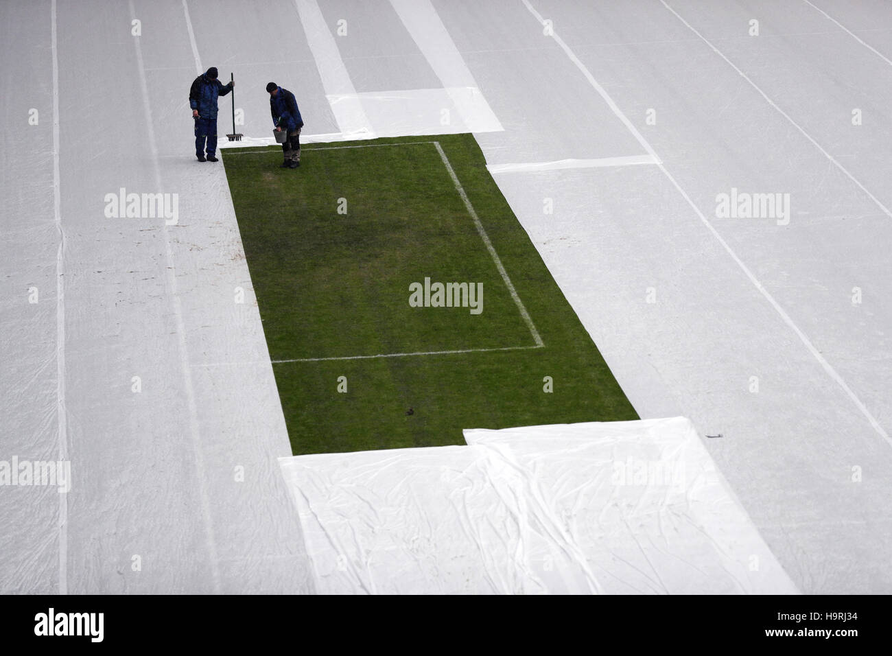Zwei Green-Keeper pflegen am 26.11.2016 in Kasan, Russland, ein Rasenstück im Kazan Arena Stadion. Das restliche Spielfeld im Stadion ist zum Schutz gegen Schnee und Frost mit einer piano abgedeckt. Am Abend findet in der Tennisakademie von Kasan die Auslosung der Gruppen für den Confederations Cup 2017 statt. Das Acht-Nationen-Turnier findet vom 17. Juni bis 2. Juli 2017 in Russland statt. Foto: Christian Charisius/dpa Foto Stock