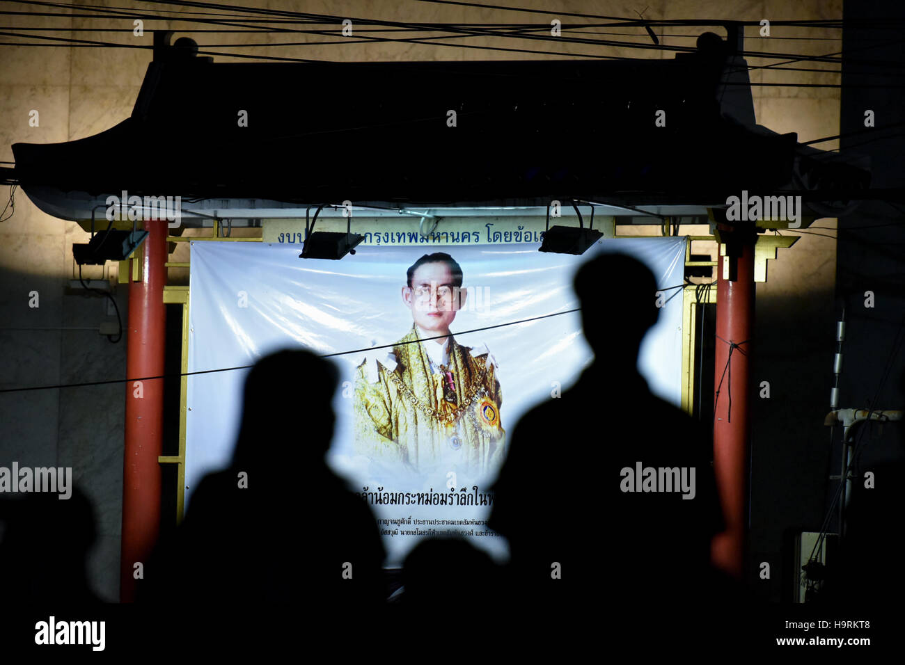 Bangkok, Tailandia. 26 Nov, 2016. Persone in lutto guardare un poster che mostra la Thailandia del compianto Re Bhumibol Adulyadej durante un lutto manifestazione svoltasi presso la Chinatown di Bangkok, Thailandia, su nov. 26, 2016. La Thailandia è stato immerso nel dolore dopo il Re Bhumibol la morte su 13 Ottobre, con il lutto e riverenza di eventi che si tengono in tutto il paese durante un anno lungo periodo di lutto. Credito: Li Mangmang/Xinhua/Alamy Live News Foto Stock
