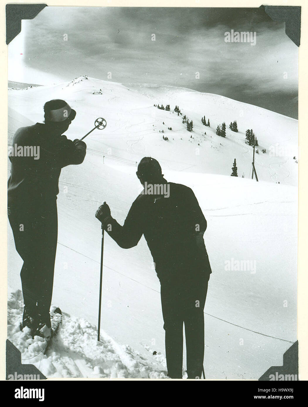 Gli sciatori valutano le condizioni e il terreno della neve nella zona sciistica di Arapahoe Basin, una destinazione popolare in Colorado, nota per le sue piste impegnative e lo sci d'alta quota. Foto Stock