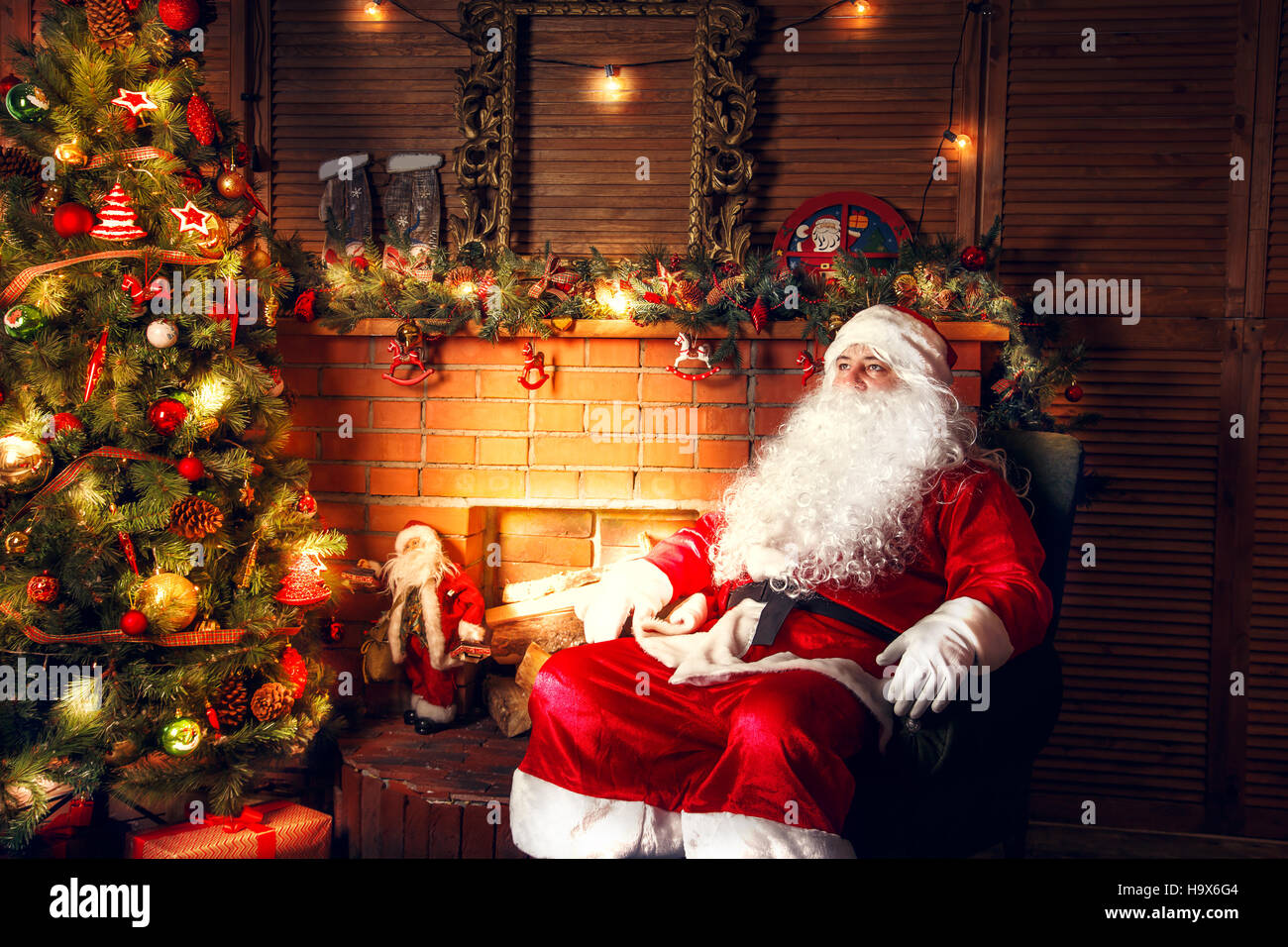 Vero Babbo Natale. Santa Claus in salotto vicino a un albero di Natale. Foto Stock