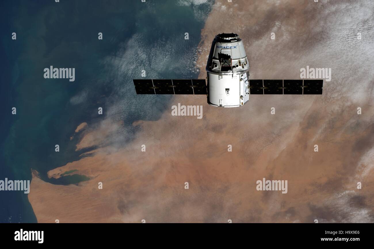 La NASA Stazione Spaziale Internazionale Expedition 41 membri dell equipaggio astronauta tedesco Alexander Gerst dell'Agenzia spaziale europea ha catturato l'SpaceX Dragon commerciale cargo craft in avvicinamento alla ISS con una vista satellitare dell Africa in background il 23 settembre 2014 dall'orbita terrestre. Foto Stock