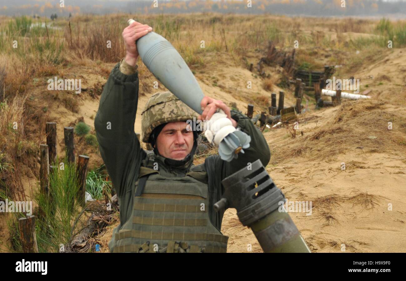 Un soldato ucraino carichi di un round in un mortaio il sistema prima di un live-fuoco esercizio di formazione a livello internazionale di mantenimento della pace e il Centro di sicurezza Novembre 9, 2016 in Yavoriv, Ucraina. Foto Stock