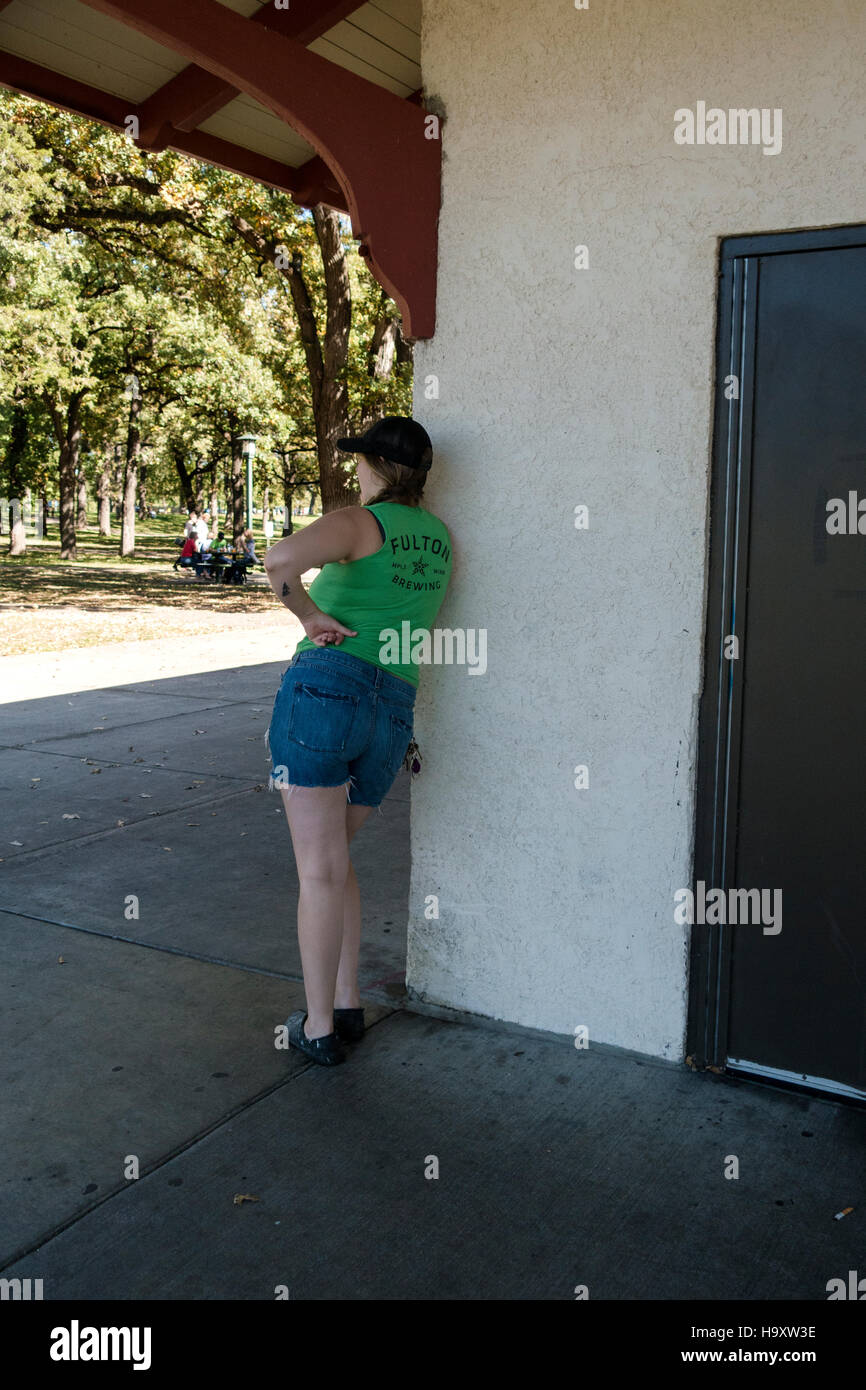 Donna prendendo un momento per godere della bellezza di Minnehaha Park. Potrebbe parlare sul suo cellulare? Minneapolis Minnesota MN USA Foto Stock