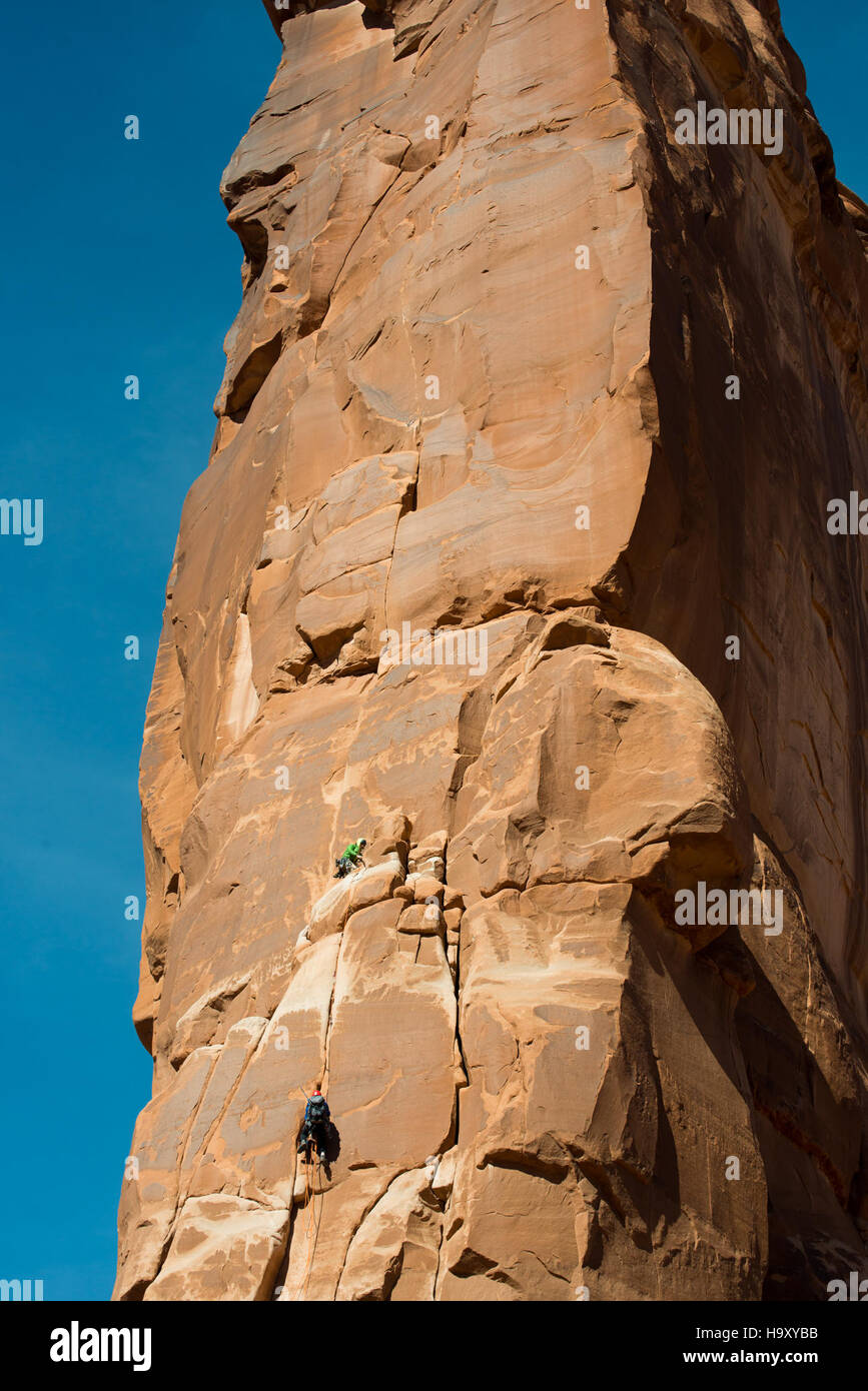Gli scalatori salgono la "Zenyatta Entrada" sulla Torre di Babele nel Parco Nazionale degli Arches, un luogo popolare per gli appassionati di arrampicata su roccia, che offre viste mozzafiato del paesaggio desertico circostante. Foto Stock