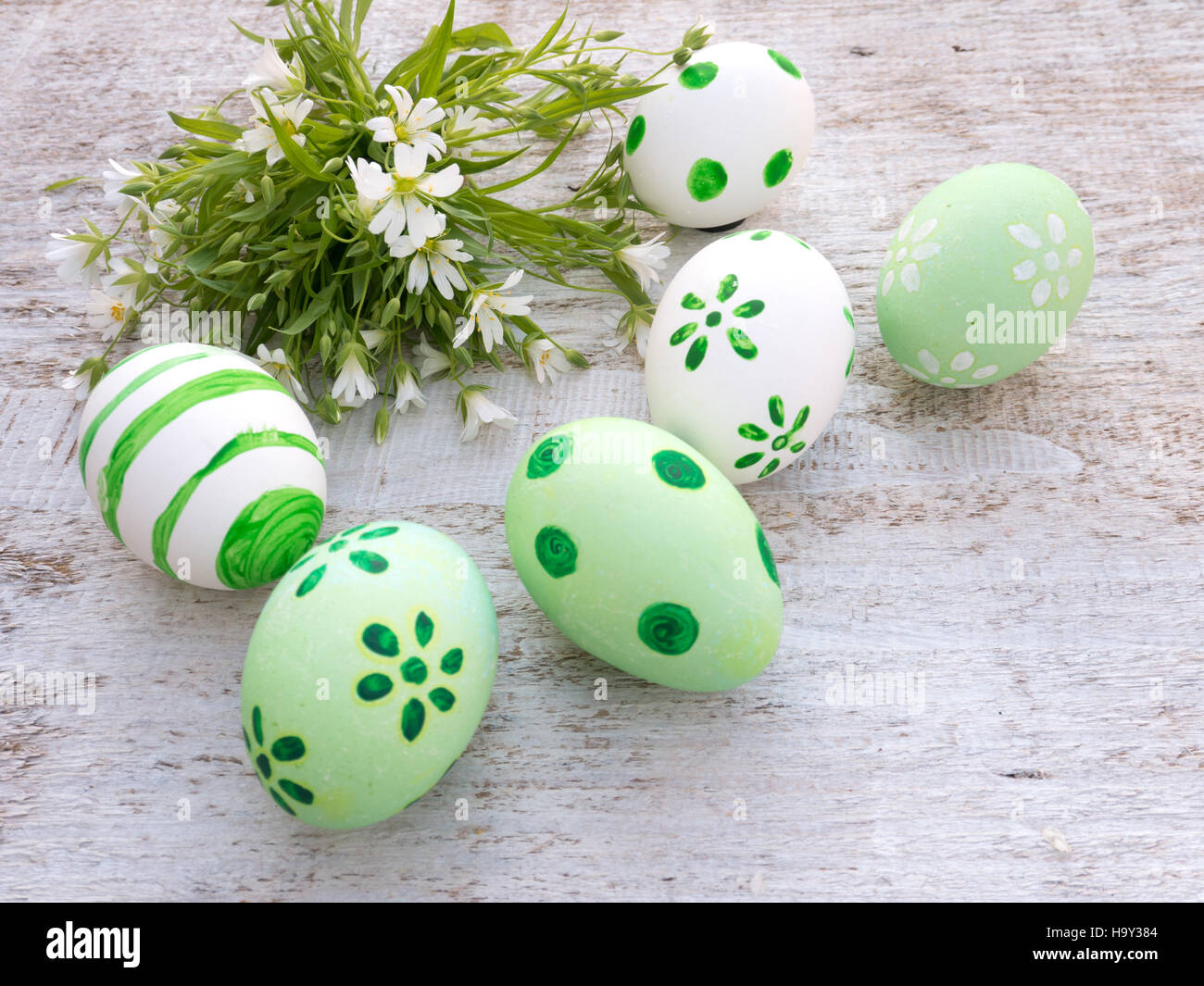 Il bianco e il verde delle uova pasquali e wild bouquet di fiori Foto Stock