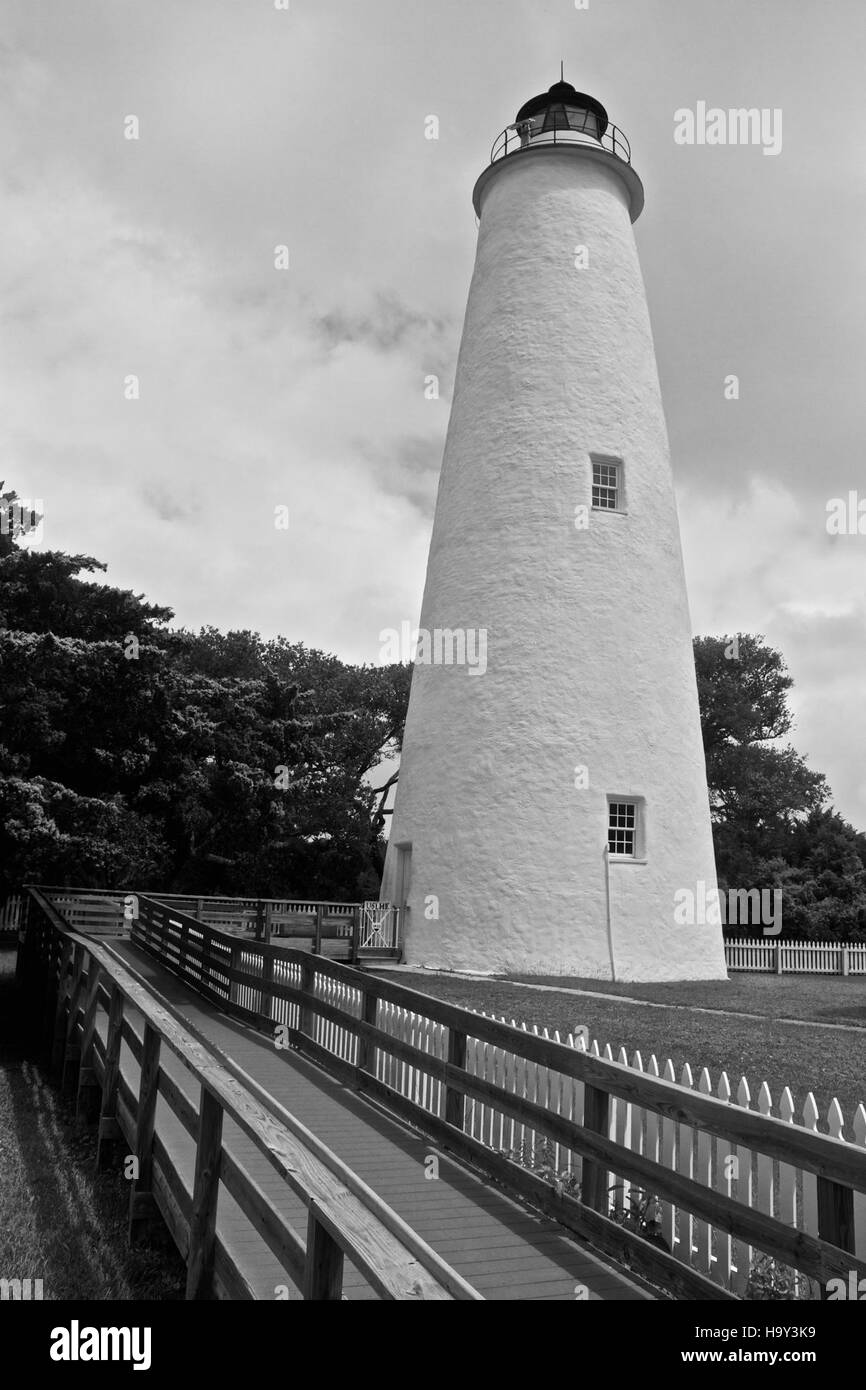 Il faro di Ocracoke, situato sull'isola di Ocracoke, si erge come un simbolo storico nel Cape Hatteras National Seashore. Aiuta a guidare i marinai preservando al contempo il patrimonio naturale e culturale dell'isola. Foto Stock