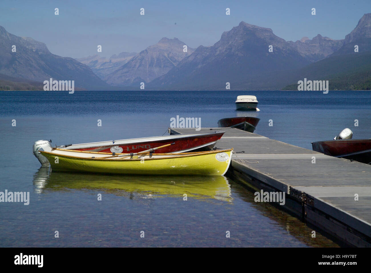 Le barche sono legate sulle rive del lago McDonald, situato nel Glacier National Park. Il lago è un popolare luogo ricreativo per andare in barca, andare in kayak e pescare, contribuendo all'offerta turistica all'aperto del parco. Foto Stock